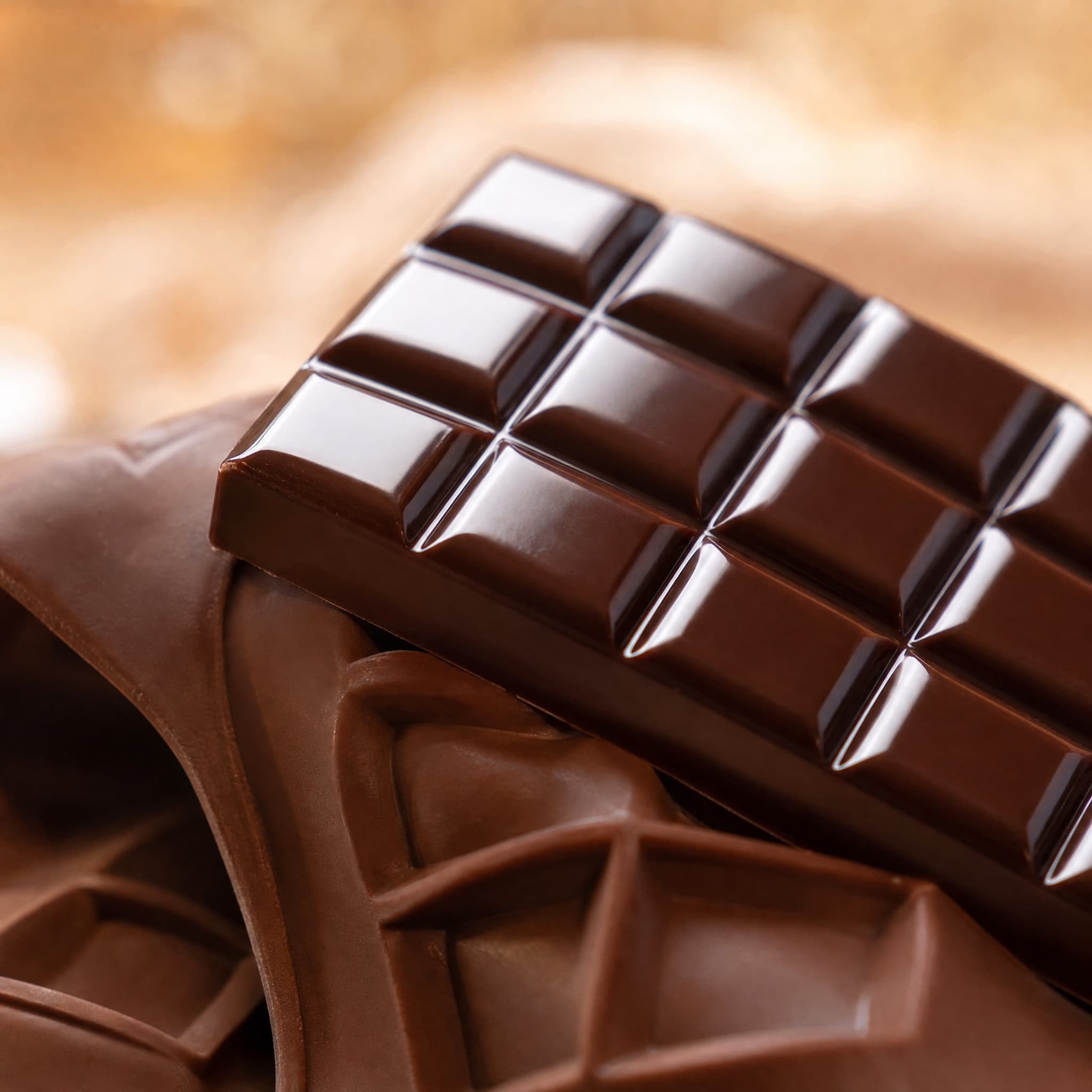 A glossy chocolate bar releasing from a silicone mould